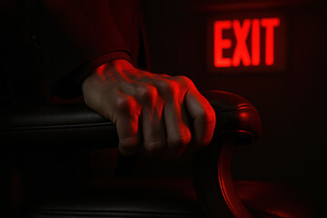 Glowing red exit sign signals emergency while grip expresses alert warning and rising tension