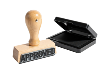 A wooden stamp with the word 'APPROVED' on it, placed next to an open stamp box.