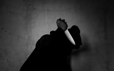 Mysterious man wearing black hoodie holding a knife to stab someone. Crimes and criminality concept