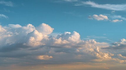 Obraz premium A wide expanse of sky filled with soft glowing clouds in golden light, creating a clean and serene background with airy textures.