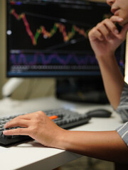 Cropped photo of businessman analyzing business diagram, marketing statistics and finance market graphs on computer monitor in the office.