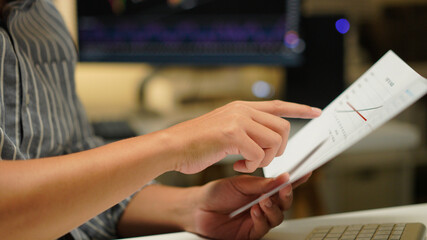 Obraz premium Cropped photo of businessman analyzing business diagram, marketing statistics and finance market graphs on computer monitor in the office.