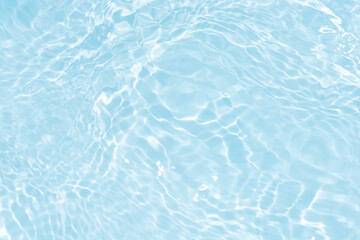 Obraz premium Blue water with ripples on the surface. Defocus blurred transparent blue colored clear calm water surface texture with splashes and bubbles. Water waves with shining pattern texture background.