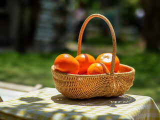 Oranges in a basket on a table with a green grass background