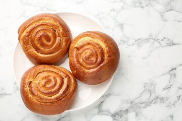 Tasty roll buns on white marble table, top view. Space for text
