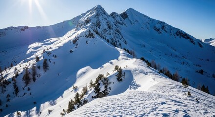 Snowy mountain peaks under a bright blue sky, winter landscape.