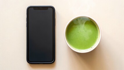 New Year Reset & Minimal Tech Lifestyle concept. A smartphone next to a cup of green beverage on a light surface.