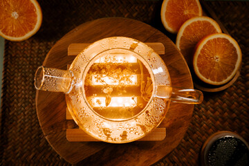 Sipping fragrant green tea with orange slices in a cozy setting at sunset