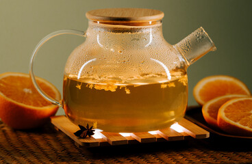 Enjoying a warm cup of green tea with orange slices in a cozy setting during the afternoon