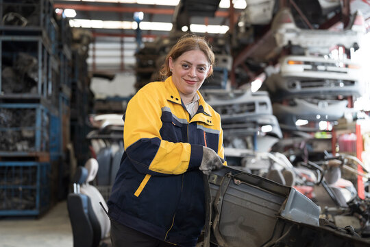 Automotive spare parts warehouse or auto parts warehouse. Female warehouse worker inspected spare parts in auto parts warehouse, using digital tablet check inventory in workplace