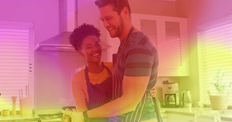 Stirring romantic couple cooking eggs in frying pan in home kitchen, with striped aprons