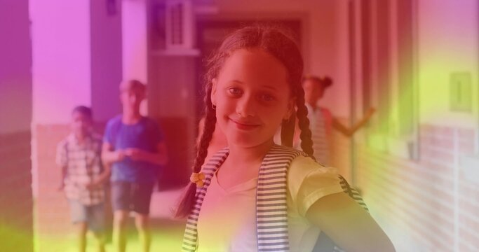 Smiling school-age girl walking down bright school hallway, with backpacks, brick walls and windows - Powered by Adobe