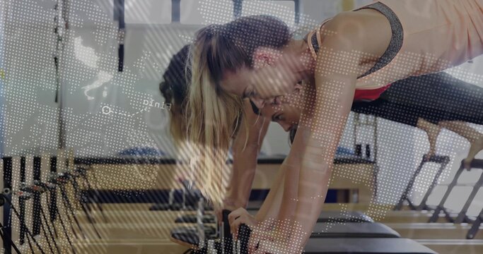 Leaning woman in sportswear gripping reformer foot bar in Pilates studio, world map overlay