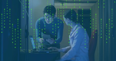 Leaning technician reviewing tablet, colleague typing laptop in data center, streaming binary