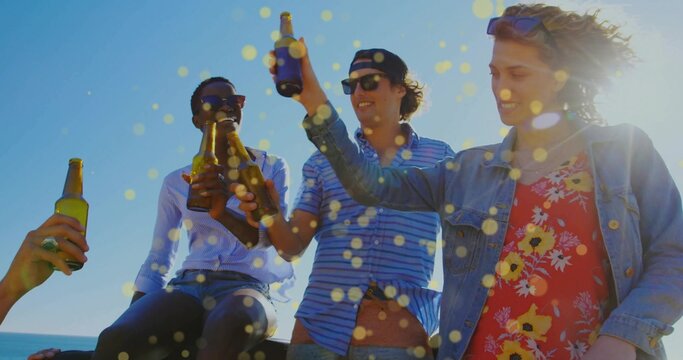 Toasting friends wearing casual summer attire at boat stern by sea, with glass beer bottles