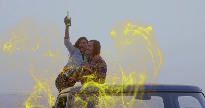 Laughing couple sitting on SUV roof at seaside, holding green bottles with yellow overlay