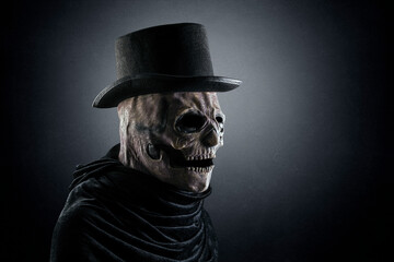 Creepy figure with black vintage top hat in the dark