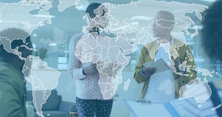 Collaborating four colleagues exchanging documents on tablet in modern office, with map overlay