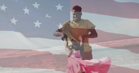 Spinning father and daughter holding hands at beach with waves, translucent stars stripes overlay