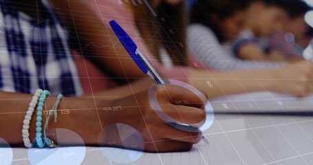 Writing student wearing bracelets gripping blue pen on notebook in classroom, digital chart overlay