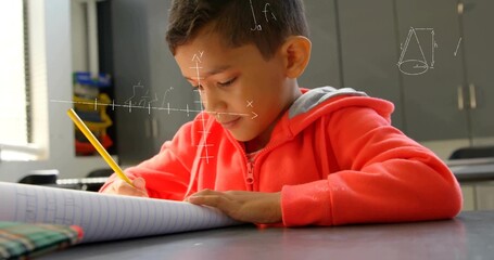 Writing boy wearing red hoodie solving math equations in classroom, with notebook and yellow pencil