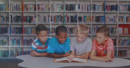 Leaning four boys reading open picture book at curved study table in library, with tall bookshelves