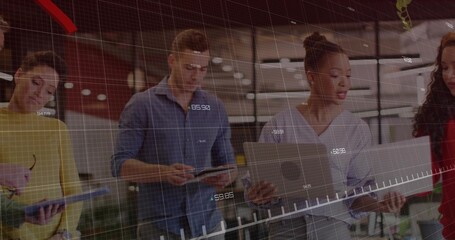 Collaborating team in business wear reviewing holographic charts in office with tablets laptops