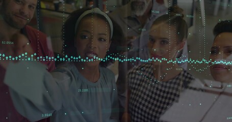 Pointing presenter and team analyzing data overlay on glass panel in office area, with tablet