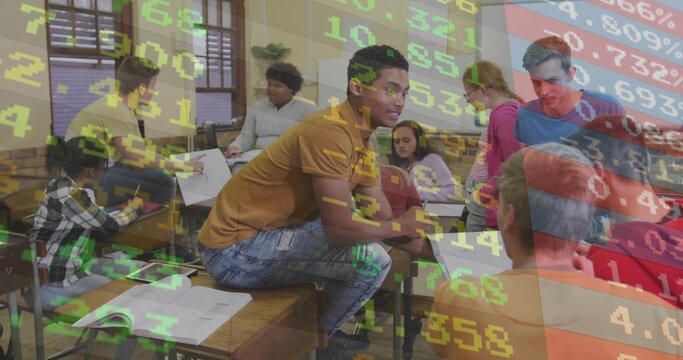 Teenage classmates collaborating around desks in classroom with finance data overlay and notebooks
