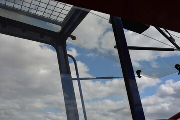 A view of the cloudy sky from inside the driver's cab of a crane