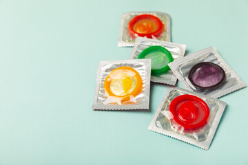 Condoms on a colored background. Colorful fruit-themed condoms in packaging. Safe sex concept. Contraceptive. Different birth control methods. Aids prevention. World AIDS Day. Sexual health.