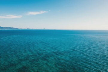 Scenic aerial view of the vast turquoise ocean meeting the horizon under a serene sky