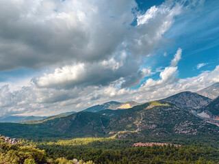 Fototapeta premium Wide valley view under cloudy sky with mountain ridges and forests
