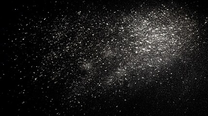 Obraz premium Scattered shimmering particles create a luminous effect against a dark background.