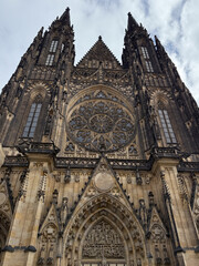 Fototapeta premium Low-angle view of the soaring Gothic buttresses and stained glass windows of St. Vitus Cathedral, emphasizing monumental height for Prague tourism, architectural studies, or European heritage marketin