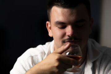 portrait d'un jeune homme buvant un verre d'alcool