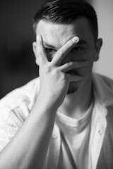 regard au travers de la main, portrait d'un jeune homme en noir et blanc