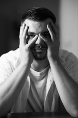 portrait noir et blanc d'un jeune homme les mains sur le visage