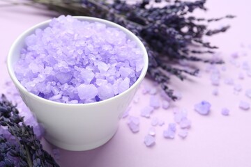 Sea salt and lavender flowers on violet background, closeup