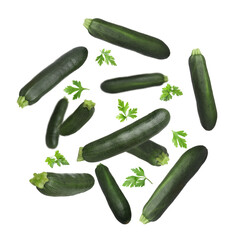 Fresh zucchini and parsley falling against white background