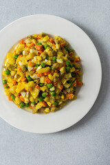 This colorful salad combines boiled eggs, tender chicken breast, diced potatoes, vibrant carrots, and green peas, all drizzled with rich olive oil for a nutritious meal