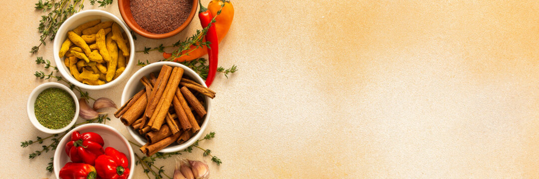 A warm display of spices and herbs on a beige background, each adding rich aromas and flavors, perfect for enhancing recipes, banner