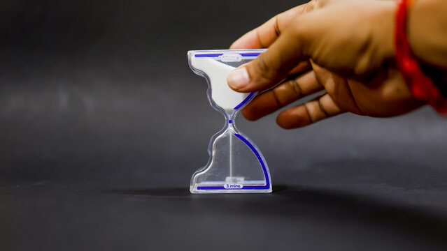 time discipline concept with hand flipping glass sand timer
