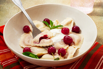 Traditional dumplings with cherries and yogurt, close-up, no people,