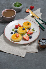 Cottage cheese pancakes (syrniki) with fresh berries on a plate