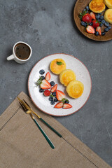Cottage cheese pancakes (syrniki) with fresh berries on a plate