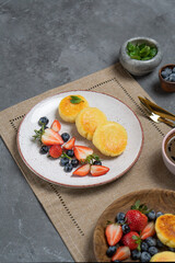 Cottage cheese pancakes (syrniki) with fresh berries on a plate