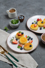 Cottage cheese pancakes (syrniki) with fresh berries on a plate