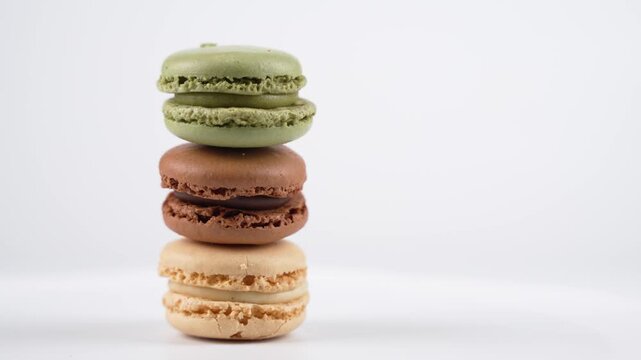 A tall macaron tower spins gracefully. Each layer reveals different flavors and colors, displayed cleanly against a white background.