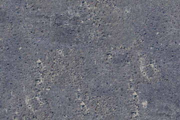 Close up of a rough dark gray asphalt texture showing fine grain and minor surface wear ideal for backgrounds or digital rendering.